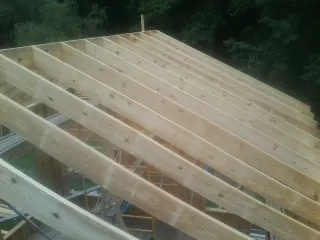 New roof rafters set over an addition before sheathing in Dana