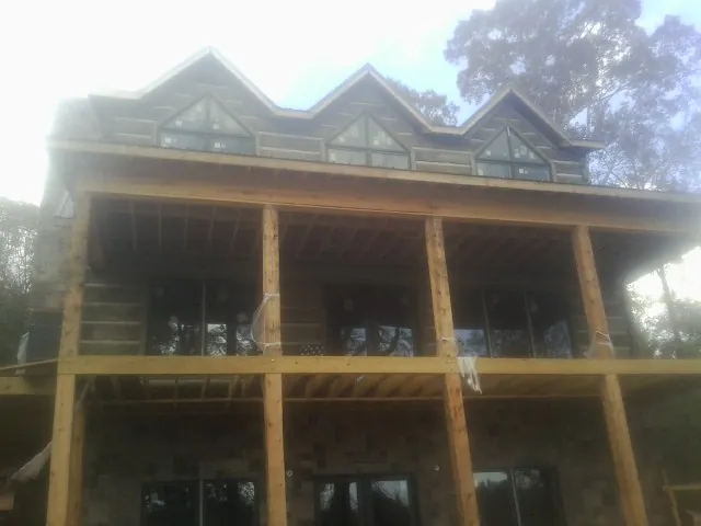 Dormers and porch framing on a large log home under construction — Roof Coating work by our crew in Dana
